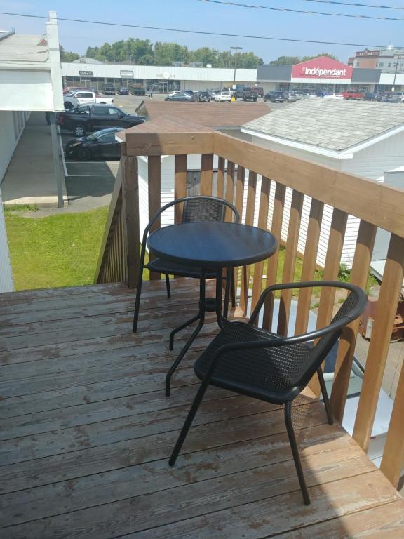 a table and two chairs on a deck at Les Logements Larocque in Shippagan