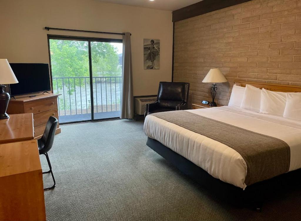 una camera d'albergo con letto, scrivania e TV di The Stagecoach Inn a Salmon
