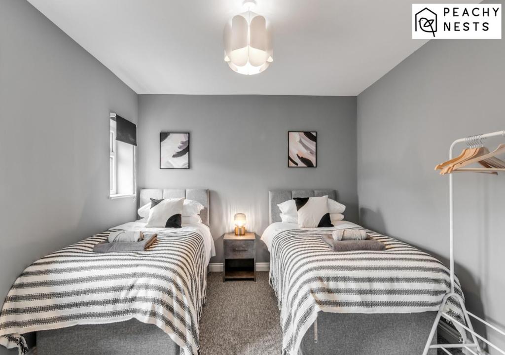 1 dormitorio con 2 camas y mantas a rayas en Contractor Pad with off-Road Parking Sleeps 5 en Norwich