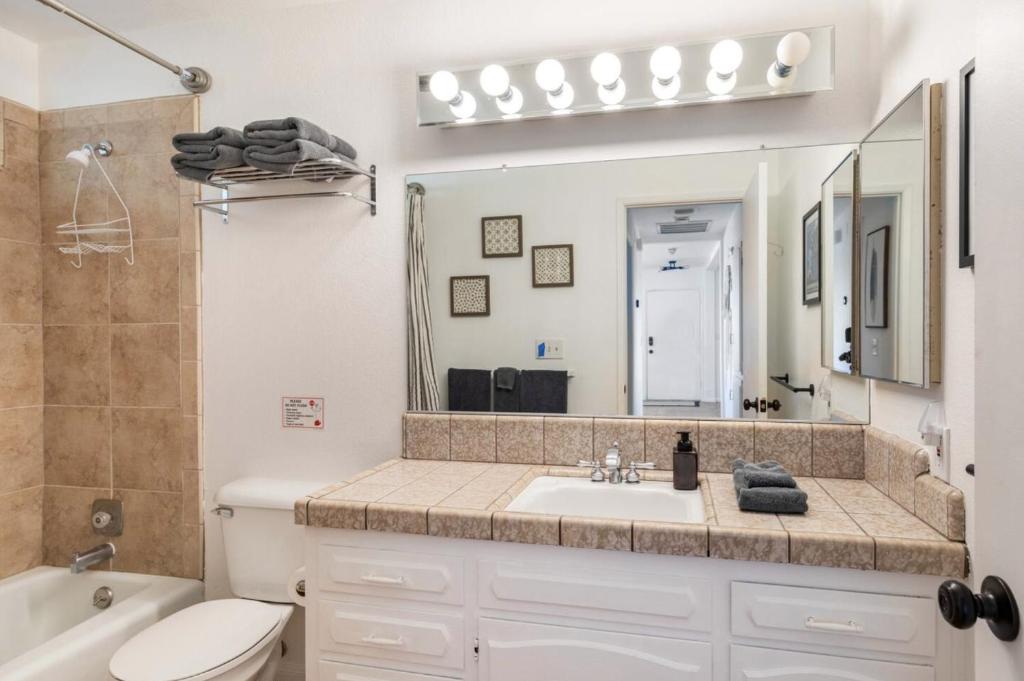 a bathroom with a sink and a toilet and a mirror at The Outpost Joshua Tree: Hot Tub, GameRoom, JTNP in Joshua Tree
