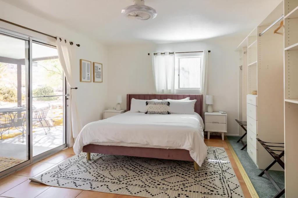 a bedroom with a large bed and a balcony at The Outpost Joshua Tree: Hot Tub, GameRoom, JTNP in Joshua Tree