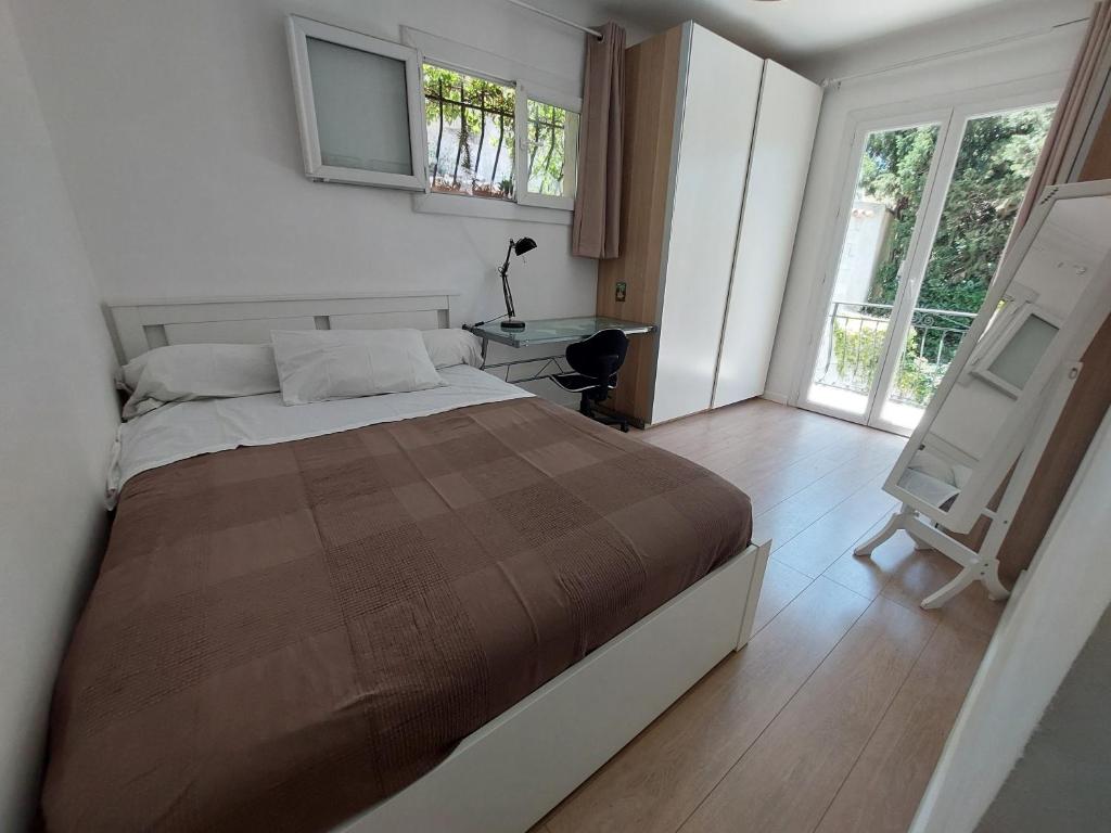 a bedroom with a bed and a desk and windows at Charmant haut de villa in Châteauneuf