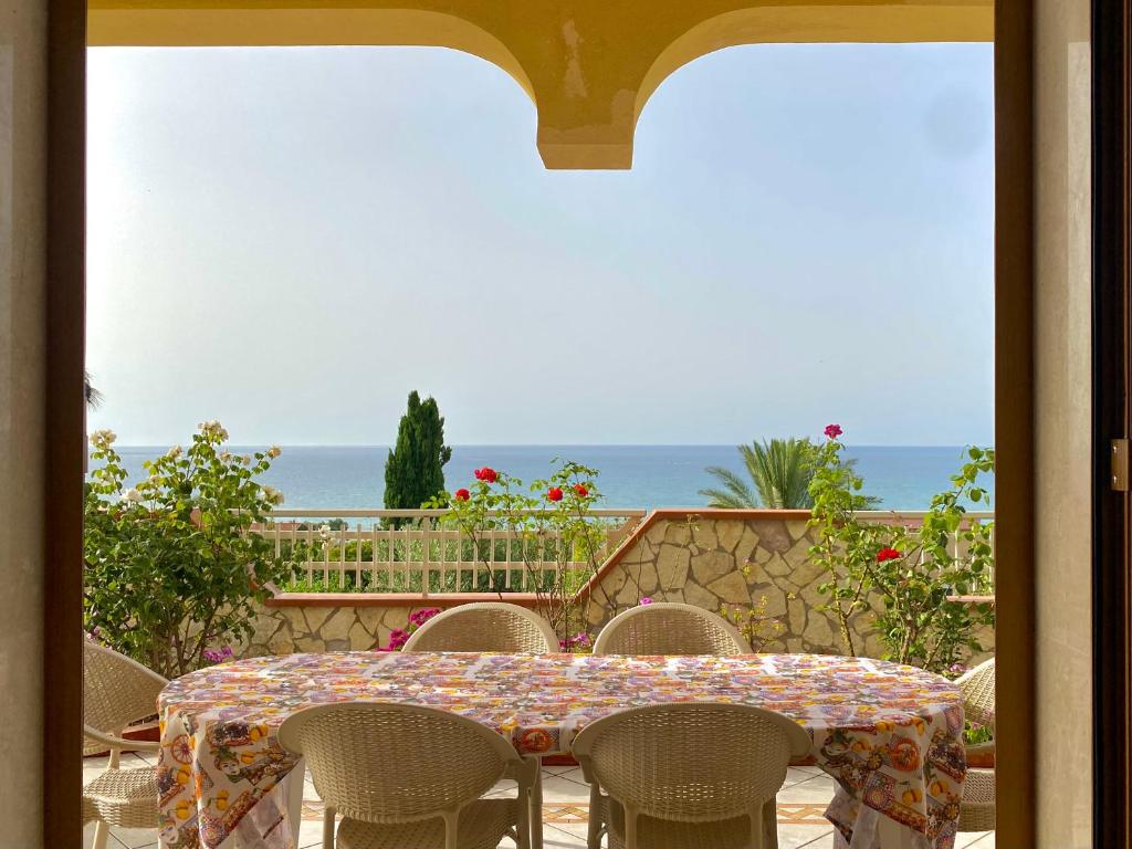 una mesa y sillas con vistas al océano en Villa Mare Giuggiola, en Alcamo Marina