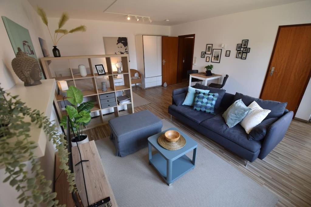 a living room with a blue couch and a table at Backnanger Terrassenstüble in Backnang