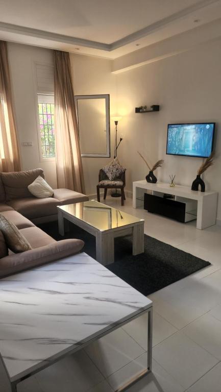 un soggiorno con divano e TV di Maison Sidi bouzid a Sidi Bouzid