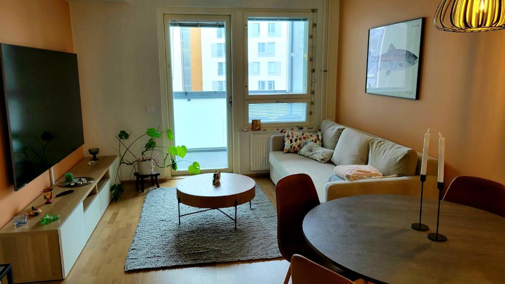 salon z kanapą i stołem w obiekcie Cosy apartment with a relaxing sauna and a balcony w Helsinkach