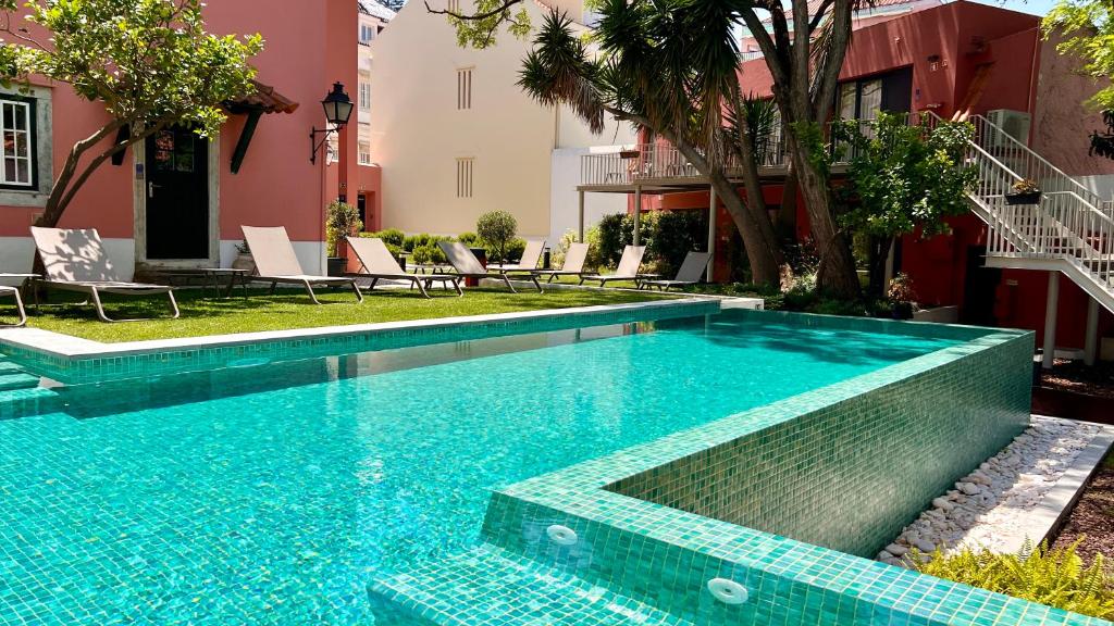 a swimming pool with blue tiles in a yard at Jardim da Lapa by Shiadu in Lisbon