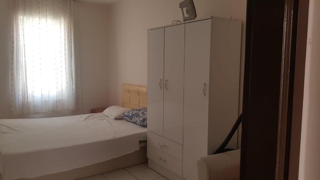 een slaapkamer met een bed en een witte kast bij SARIMSAKLI RİO BEACH KARŞISI DENİZE 0 DAİRE in Ayvalık