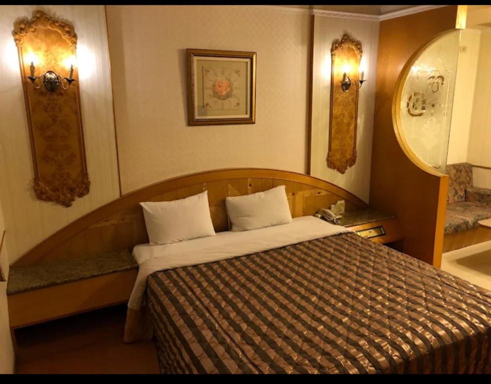 1 dormitorio con cama y espejo en Huang Jia Hotel en Yongkang