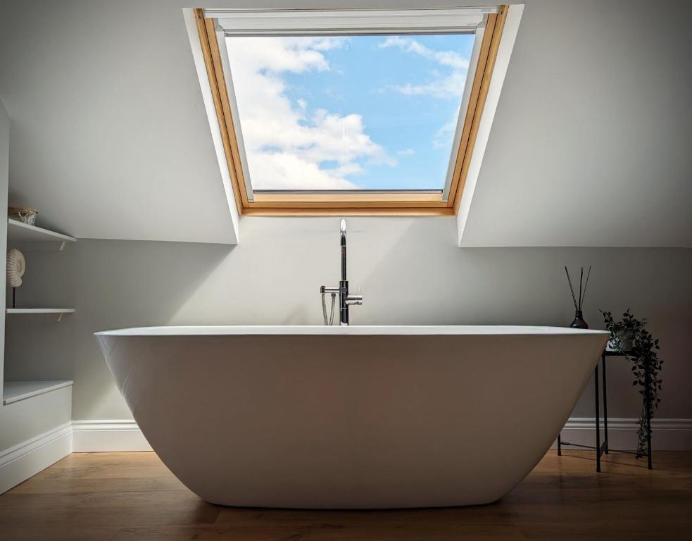 a white bath tub in a bathroom with a window at Hill View in Great Ayton in Great Ayton