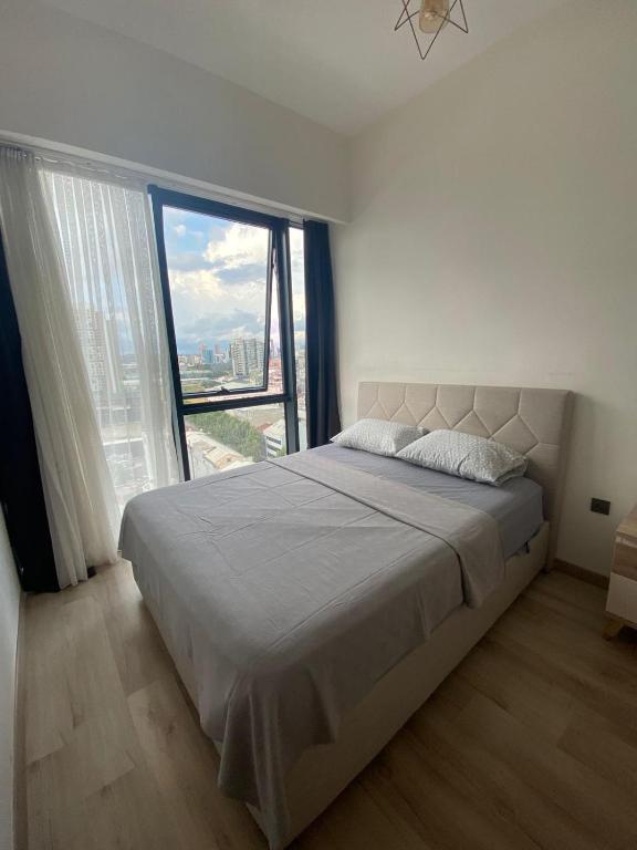 - une chambre avec un grand lit et une grande fenêtre dans l'établissement Luxry Apartment, à Istanbul