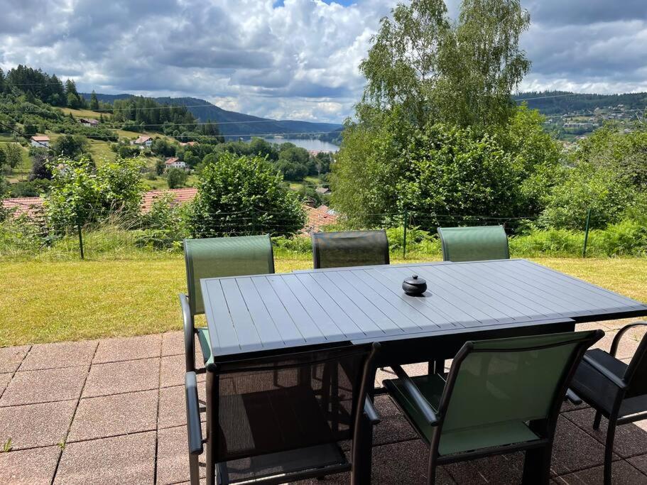 a table and four chairs on a patio at Bel appartement Magnifique vue Lac -Les Gouttridos in Gérardmer