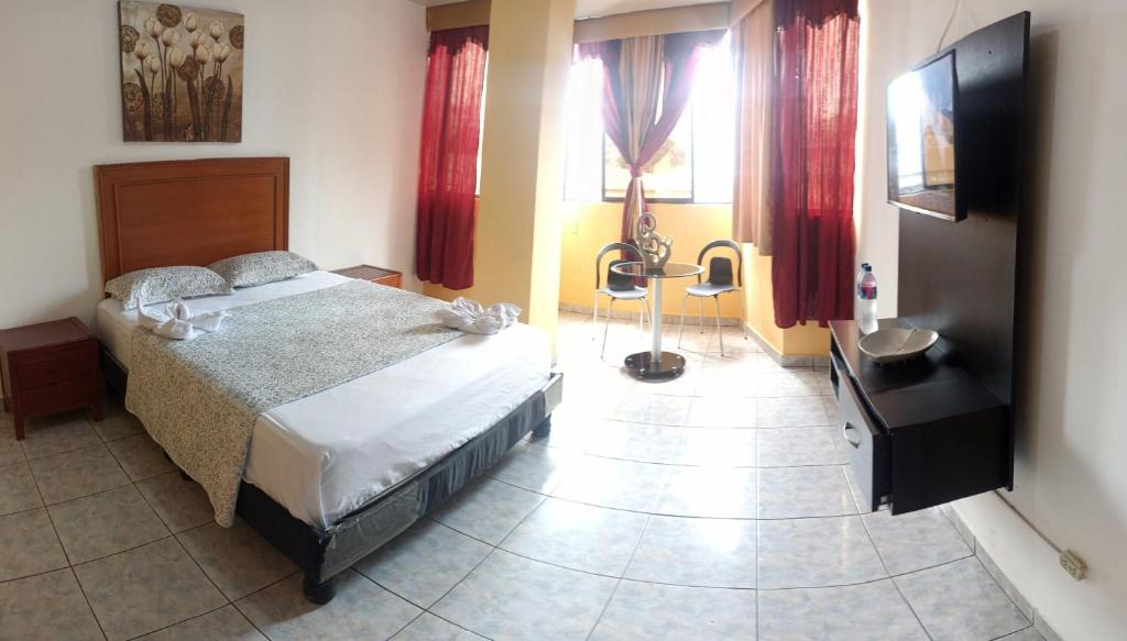 1 dormitorio con 1 cama y TV de pantalla plana en Olmedo Plaza Hotel, en Guayaquil