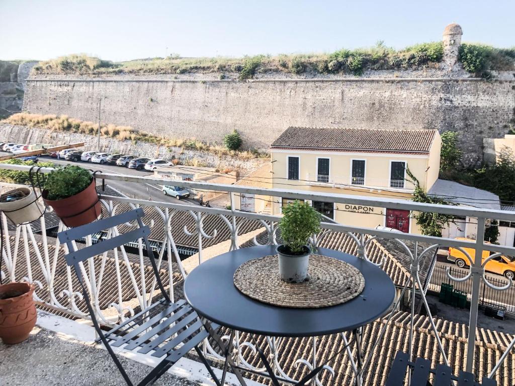 Corfu Fortress Apartment في Ágios Rókkos: طاولة مع نباتات الفخار فوق شرفة
