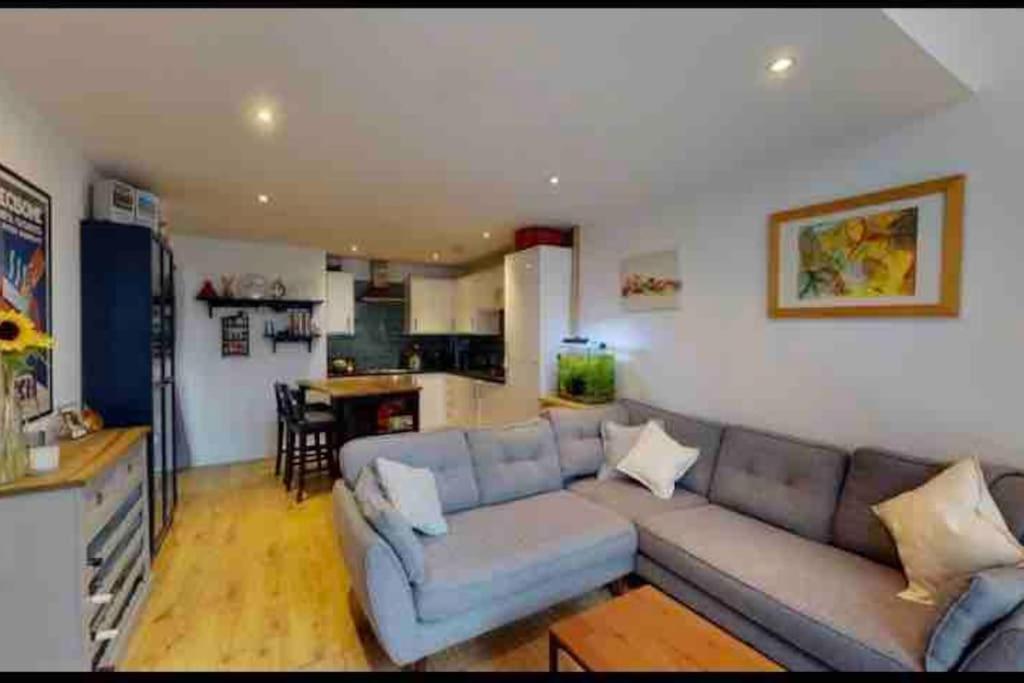 een woonkamer met een bank en een keuken bij Modern 2bed 2bath in Leith in Edinburgh