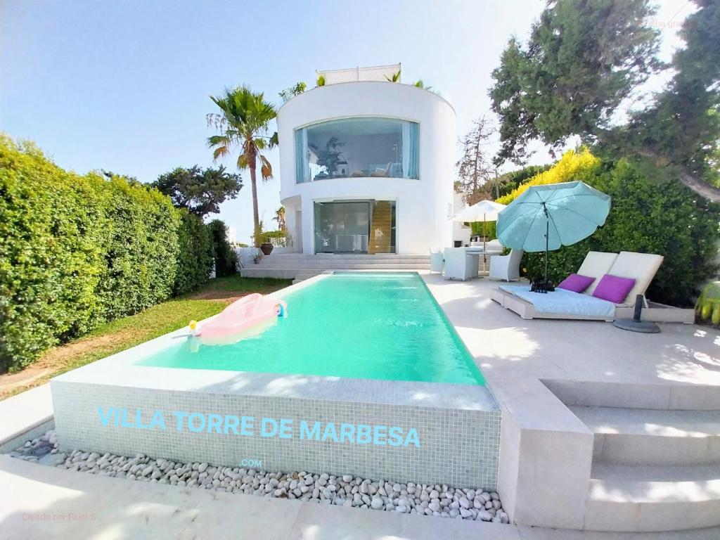 マルベーリャにあるVilla Torre de Marbesaの家の前にスイミングプールがある家