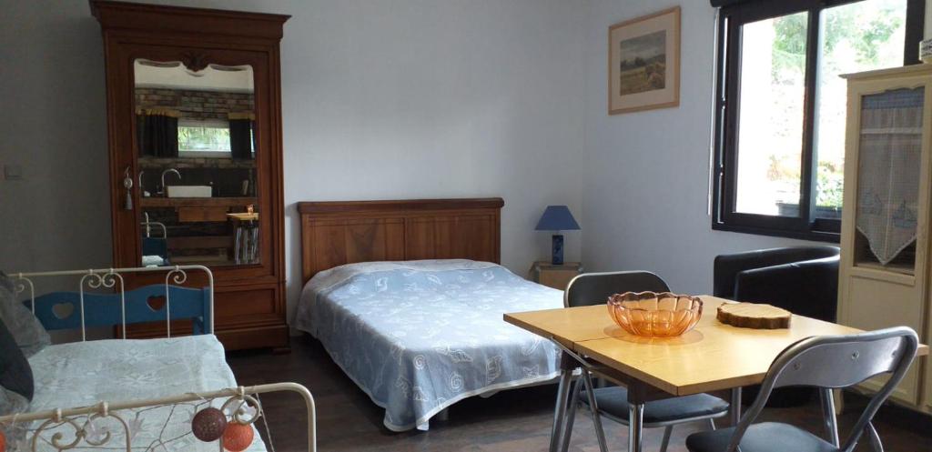 Schlafzimmer mit einem Bett, einem Tisch und Stühlen in der Unterkunft L'établi in Chécy