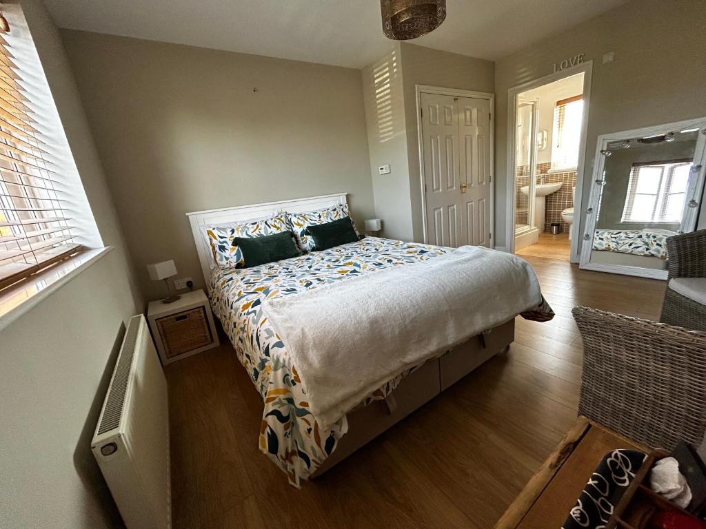 a bedroom with a large bed and a living room at Flavian House in Chichester