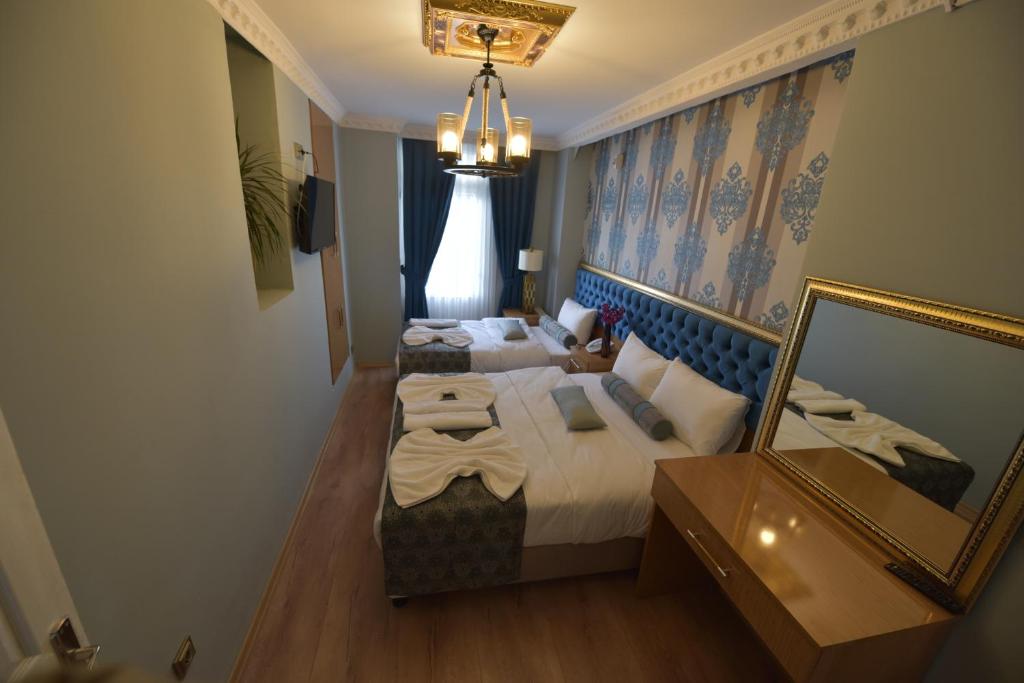 a hotel room with two beds and a mirror at GOLDEN PALACE SEA ViEW in Istanbul