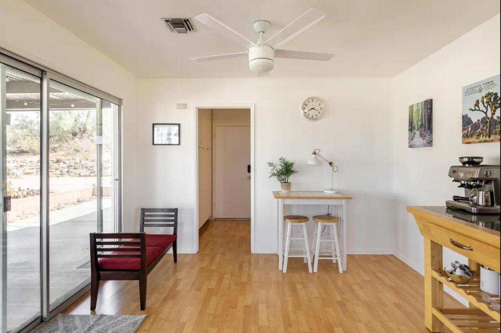 a kitchen and living room with a ceiling fan at The Outpost Joshua Tree: Hot Tub, GameRoom, JTNP in Joshua Tree