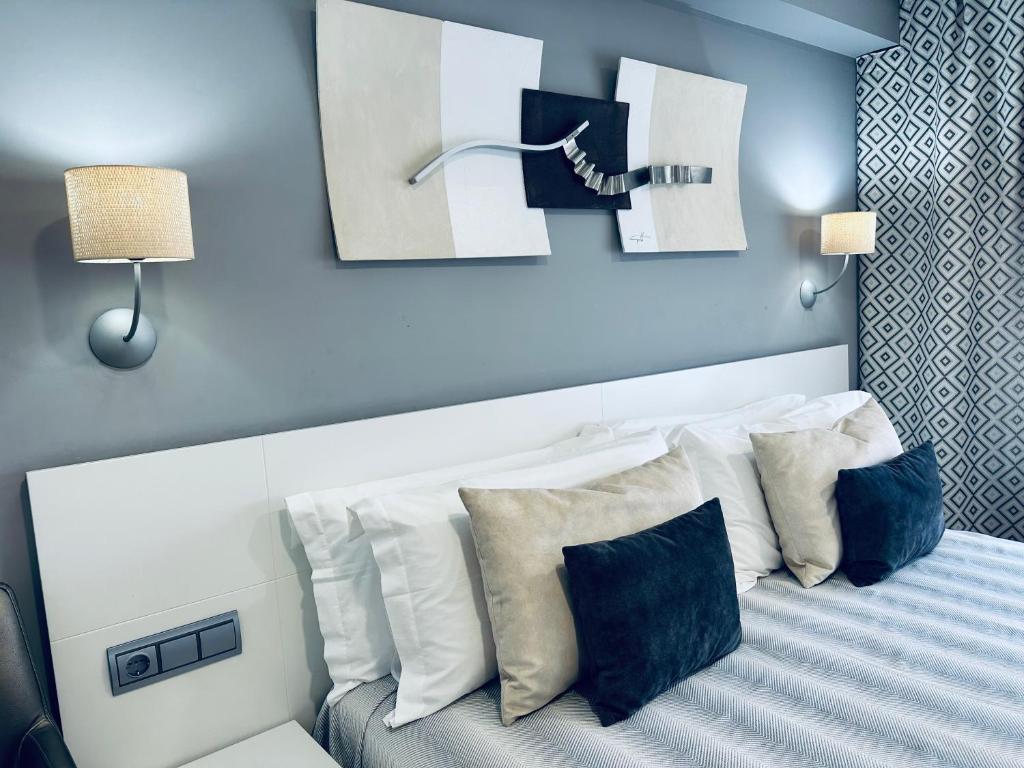 a bedroom with a bed with white pillows at Hotel Las Olas in Noja