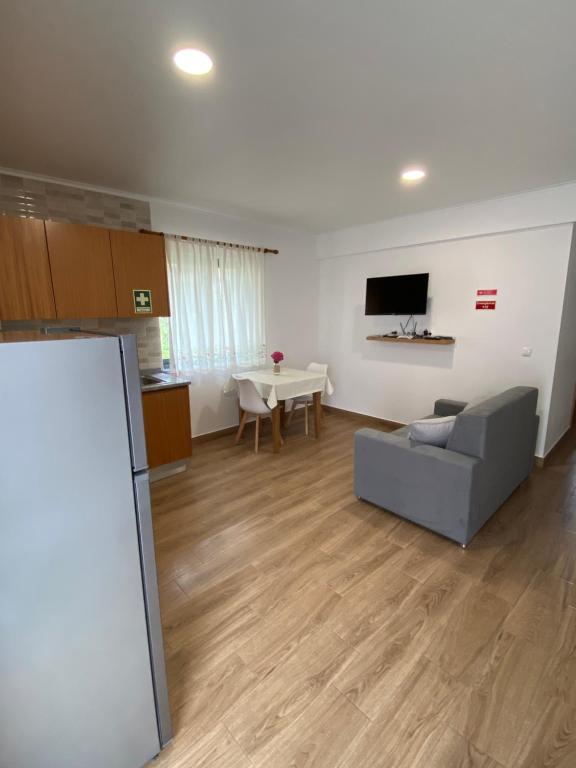ein Wohnzimmer mit einem Sofa und einem Tisch in der Unterkunft Apartamentos 4 estações in Faja Grande