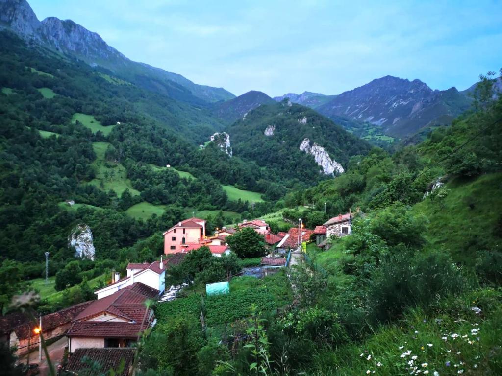 un pueblo en una colina con montañas en el fondo en MIRADOR DE LAS UBIÑAS, en Ríospaso