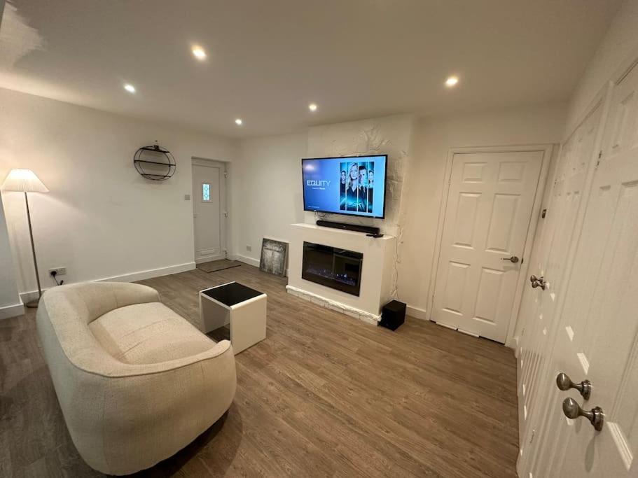 ein Wohnzimmer mit einem Sofa und einem TV in der Unterkunft Modern 1 Bedroom Studio Flat in Northfleet