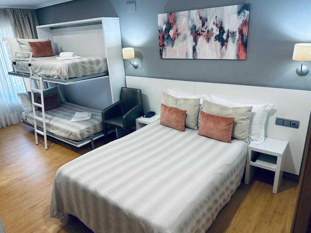 a small room with a bed and a chair at Hotel Las Olas in Noja