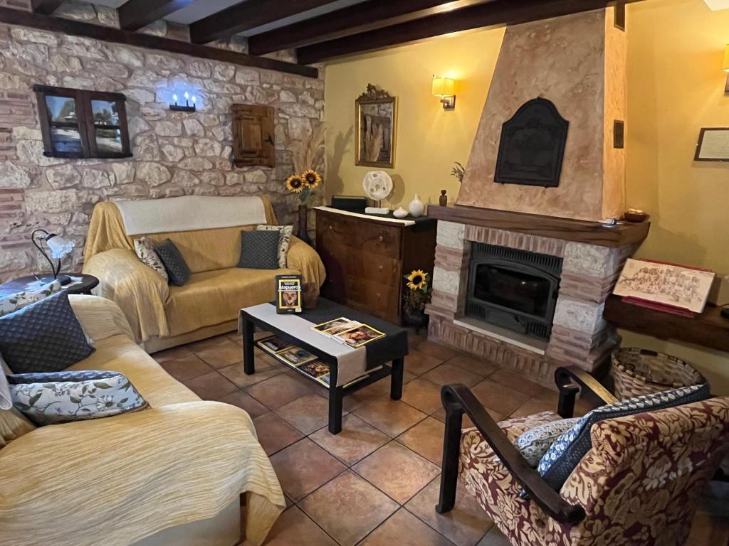 una sala de estar con dos sofás y una chimenea en La Cabala de Ibeas, en Ibeas de Juarros