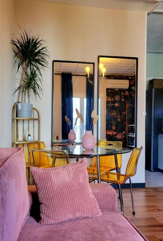 une salle à manger avec une table, des chaises et un miroir dans l'établissement Petit appartement à 50m à pied de la mer, à Fréjus