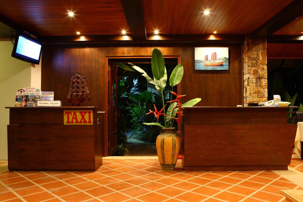 eine Lobby mit einer Rezeption und einer Pflanze in der Unterkunft Pai Tan Villas - SHA Extra Plus in Strand Bang Tao