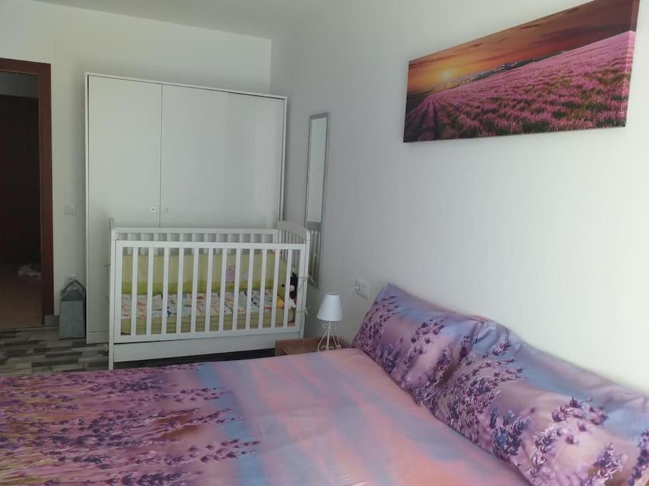 a bedroom with a purple bed and a crib at Cal Cucu in Gerp