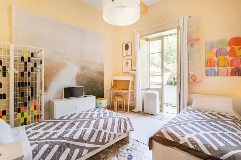 una camera con due letti e una finestra di Three Rooms a Messina