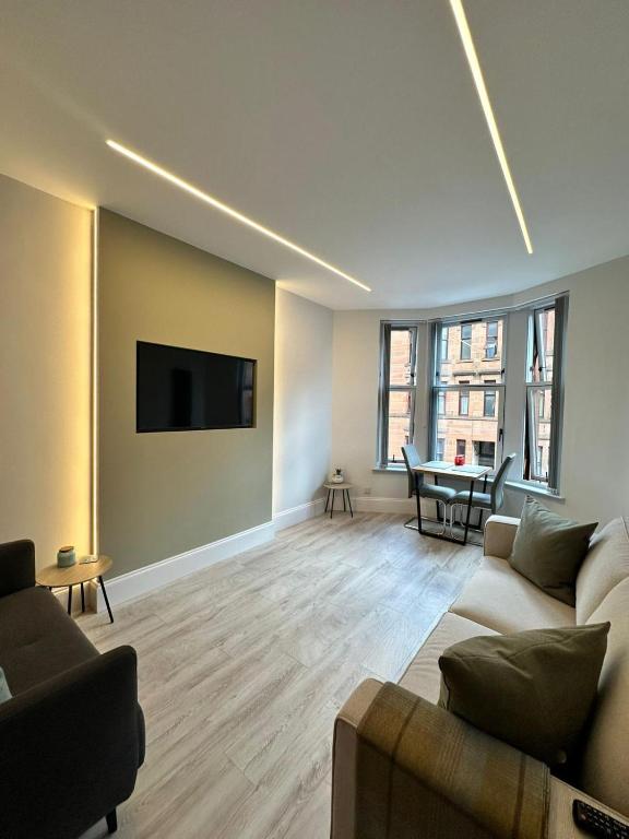 uma sala de estar com um sofá e uma televisão de ecrã plano em Glasgow West End Tenement Apartment em Glasgow