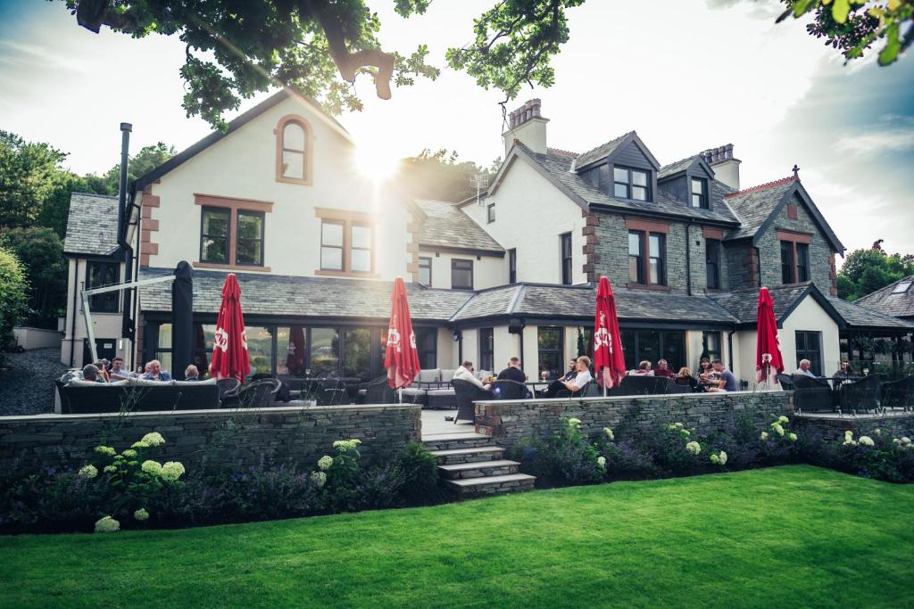 un groupe de personnes assises devant un bâtiment dans l'établissement The Ruddings, à Keswick