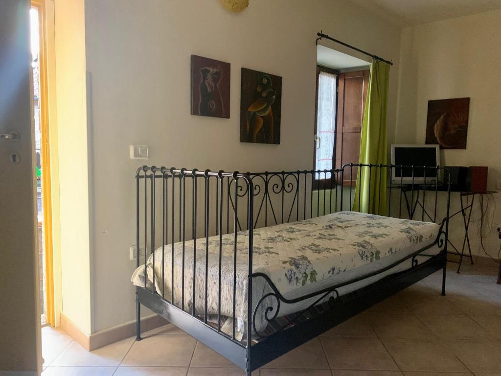 uma cama de metal num quarto com um quarto em Affittacamere Dodo em Villafranca in Lunigiana