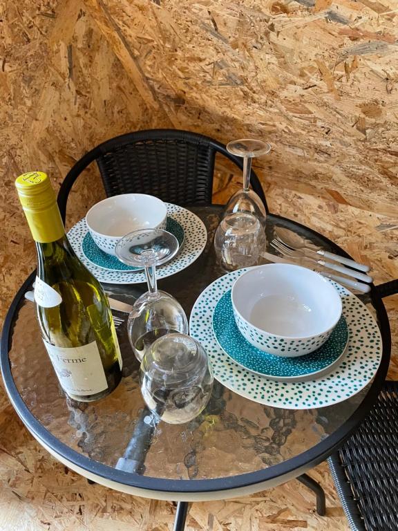 a glass table with a bottle of wine and glasses at Robin Goch Retreat in Carmarthen