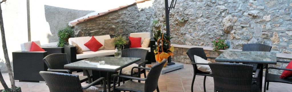 un restaurante con mesas y sillas y una pared de piedra en Bed and Breakfast Rio Casaletto, en Casaletto Spartano