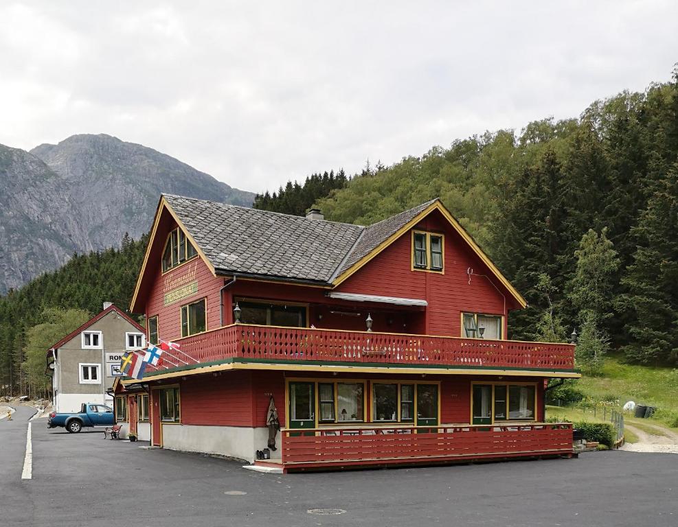 a large red building in a parking lot at Kvamsdal Pensjonat 1 in Eidfjord
