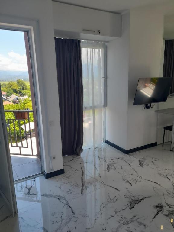 a living room with a marble floor and a television at Gaukmebulia in Siskala