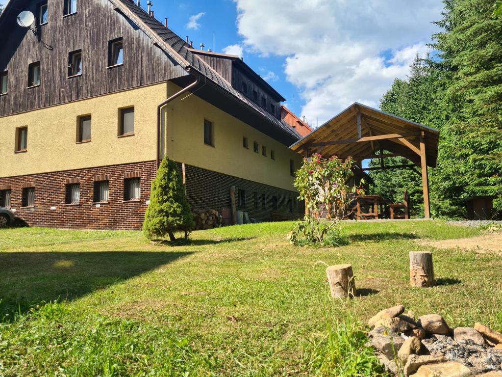 duży budynek z drewnianym dachem na polu trawiastym w obiekcie Apartmán Cardovi w mieście Dolní Morava