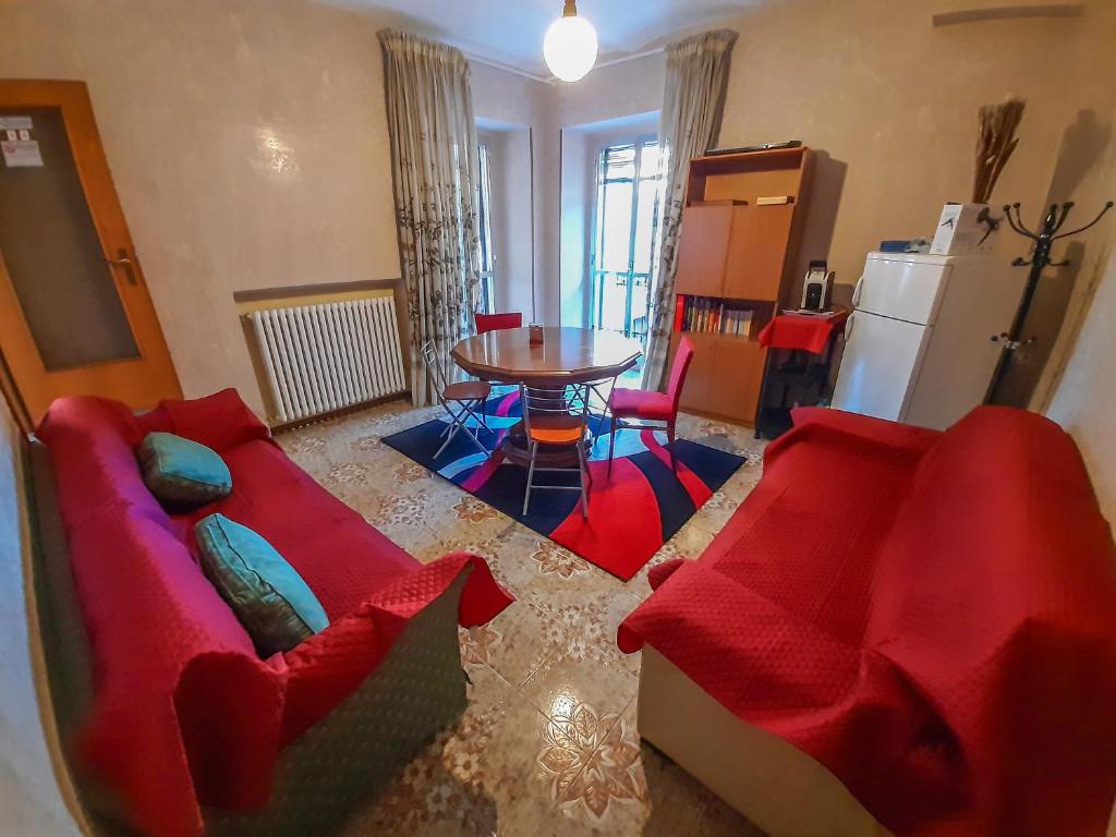 sala de estar con sofá rojo y mesa en Bed & Breakfast "Il Ghiro", en San Martino sulla Marruccina
