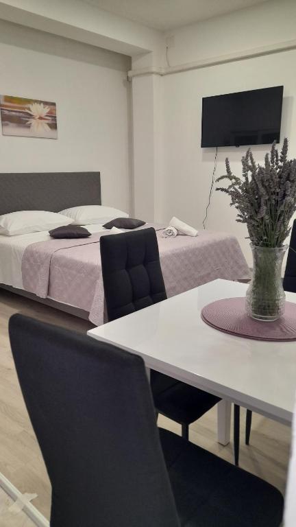 Zimmer mit einem Bett und einem Tisch mit Stühlen in der Unterkunft Ellamar City Center Apartment 2 in Makarska