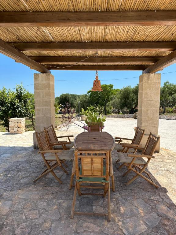 a wooden table and chairs on a patio at Trulli Santa Maria Odegitria Relais in Ostuni
