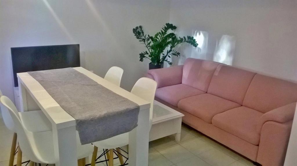 a living room with a pink couch and a table at Apartment for 6 people with parking near beach Trstenik in Split
