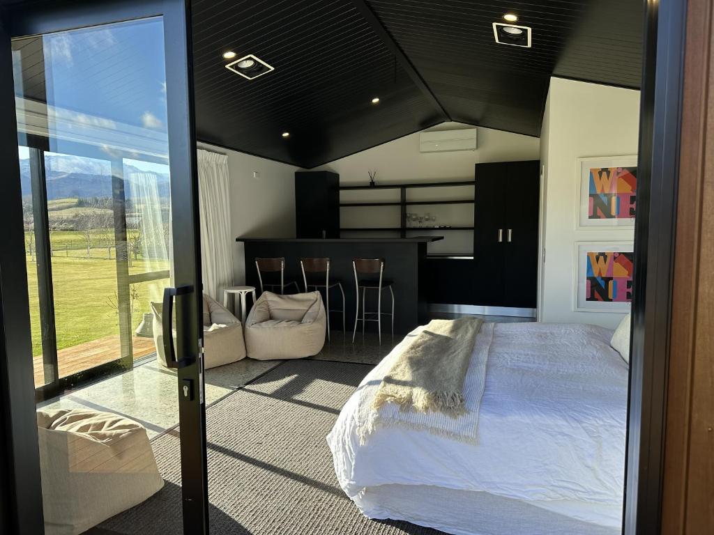 a bedroom with a large bed and a kitchen at Guest House with a Stunning View in Frankton Wharf