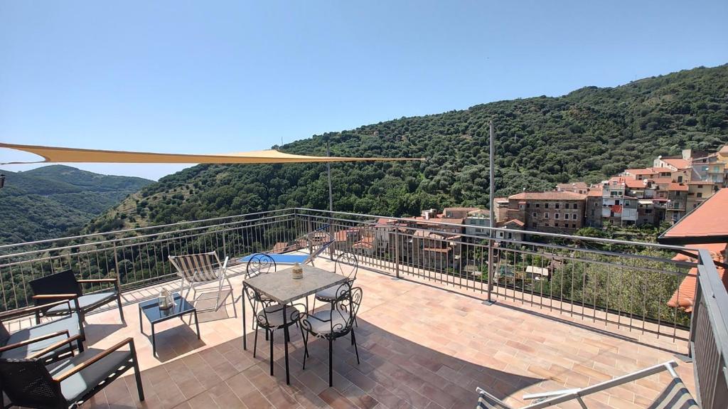 een balkon met een tafel en stoelen en een berg bij Cerasa in Rodio
