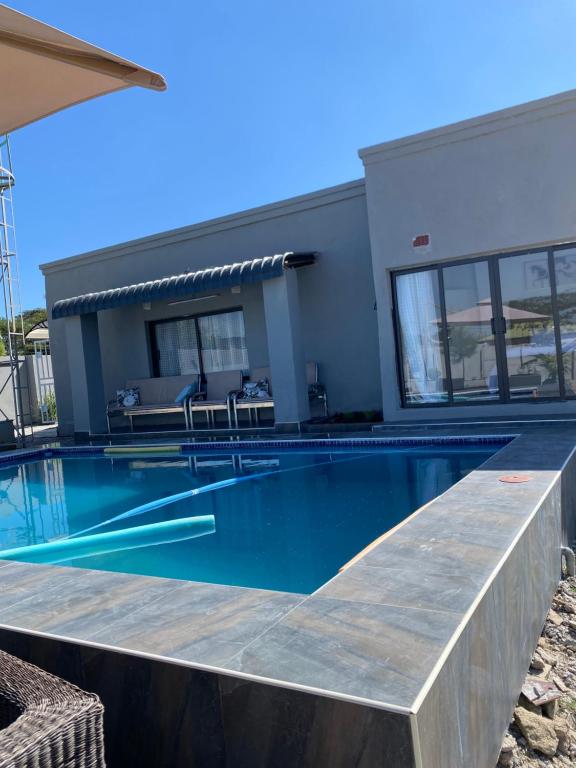 a swimming pool in front of a house at Swiss Luxury Apartments in Ndola