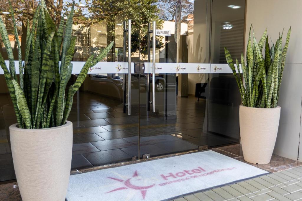 two white vases with plants in the front of a store at A1 hotel in Foz do Iguaçu